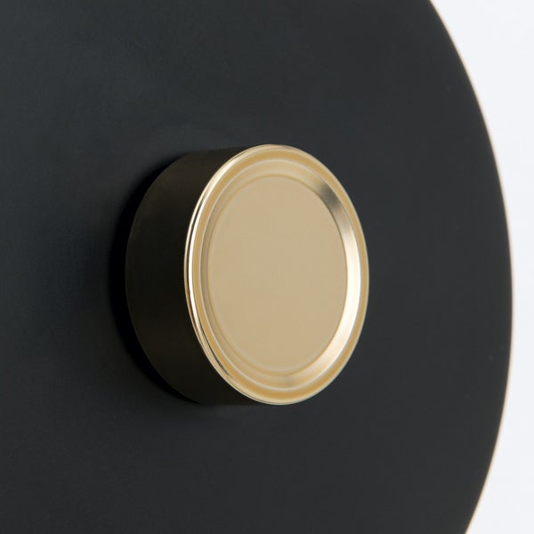 Detail einer schwarzen Wandleuchte mit goldfarbenem Akzent