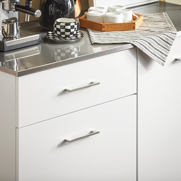 Küchenszene mit Kaffeemaschine, Geschirr und weißen Schränken mit Griffen