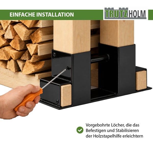 Eine Hand schraubt die Trutzholm Holzstapelhilfe an einen Kantholzpfosten zur einfachen Montage und Stabilisierung des Brennholzstapels.