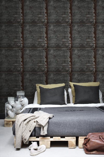 Schlafzimmer mit Bett auf Paletten und Wandtapete in Fliesenoptik