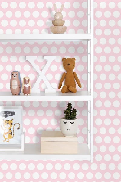 Regal mit Dekorationselementen und Spielzeug vor einem Hintergrund mit Punktmuster