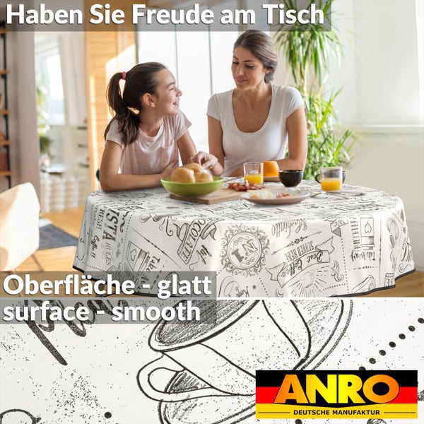 Mutter und Tochter sitzen an einem Tisch mit glatter Tischdecke und Kaffeemotiven.