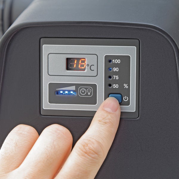 Bedienfeld eines Geräts mit einer Digitalanzeige von 18 Grad Celsius, Prozentangaben für die Leistung und einer Hand, die eine Taste drückt.