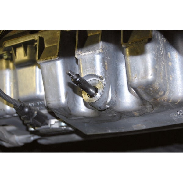 Starthilfegerät beim Überbrücken eines Autos mit geöffneter Motorhaube.