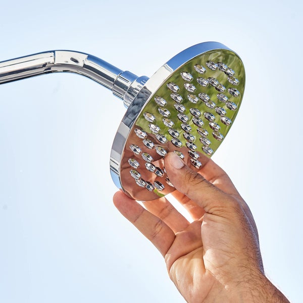 Hand hält Duschkopf.