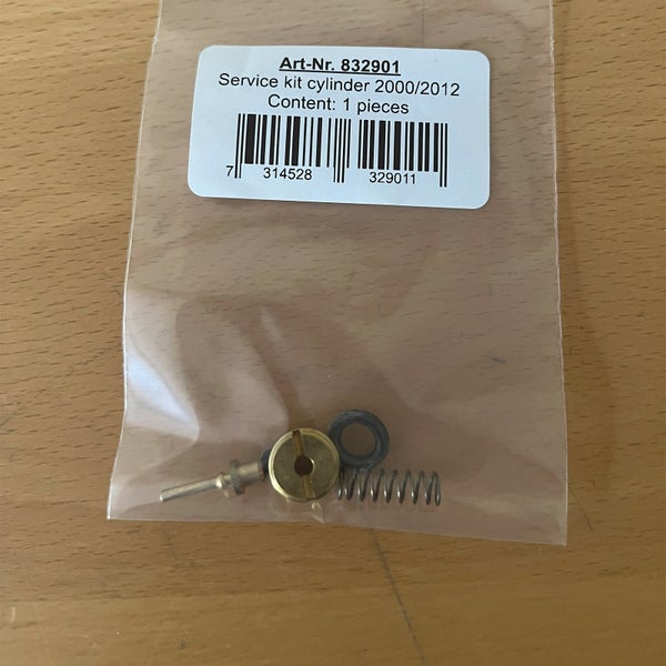 Service-Kit für Zylinder 2000/2012 im Kunststoffbeutel mit Schlitzmutter aus Messing, Metallstift, Gummiring und Feder.