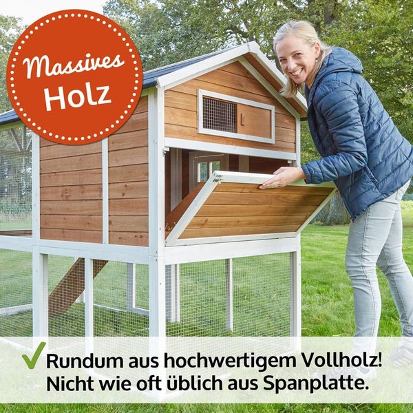 Kleintierstall aus massivem Vollholz mit weißem Rahmen und Person, die die Klappe öffnet.
