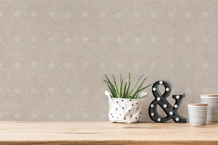Szene mit gemusterter Tapete, Pflanze und dekorativer '&'-Leuchte auf einem Tisch