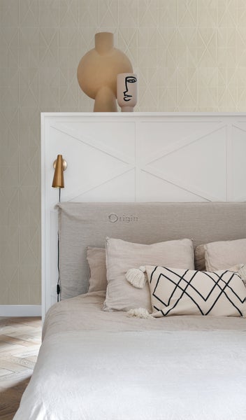 Dekoratives Schlafzimmer mit Bett, Kissen und Wanddekor