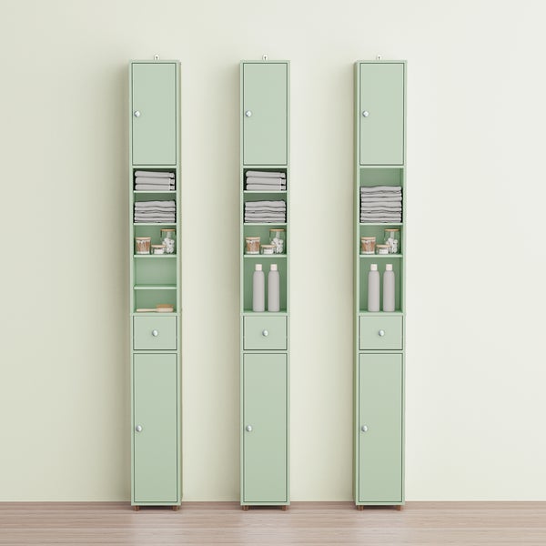 Drei schmale, grüne Badezimmerschränke mit Regalen, Schubladen und Türen