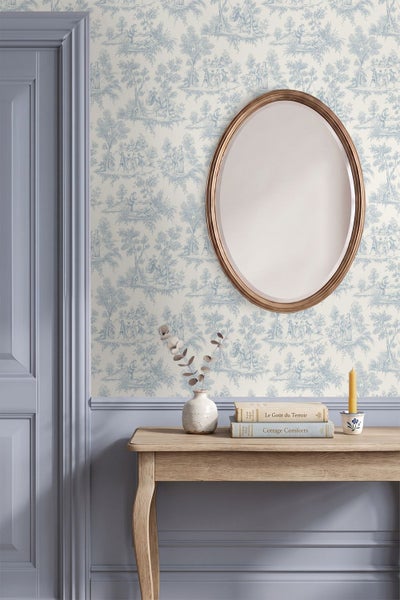 Vliestapete mit Toile-de-Jouy-Muster in klassisch gestaltetem Raum mit Konsole aus Holz, ovalem Spiegel und Wandvertäfelung.