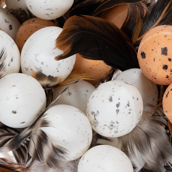Dekorative Ostereier mit Sprenkeln und echten Federn als Osterdekoration
