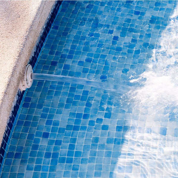 Wassereinlauf in einem gefliesten Pool mit blauen Mosaikfliesen