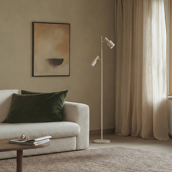 Wohnzimmer mit Sofa, Stehlampe und Kunstwerk an der Wand