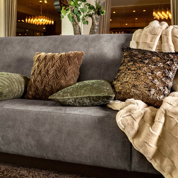 Graues Sofa mit dekorativen Kissen und Überwurf