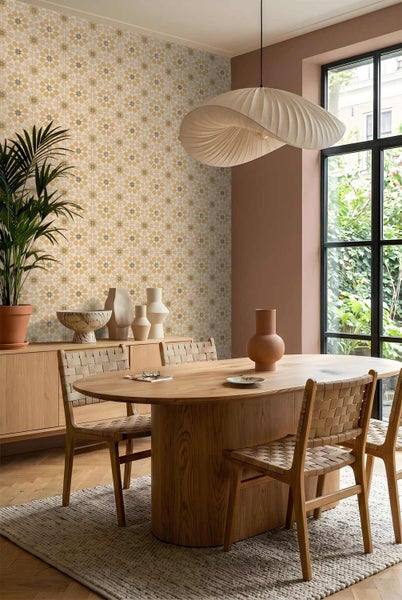 Moderner Essbereich mit ovalem Holztisch, Stühlen aus Holzgeflecht und einer Wand mit geometrisch gemusterter Tapete.