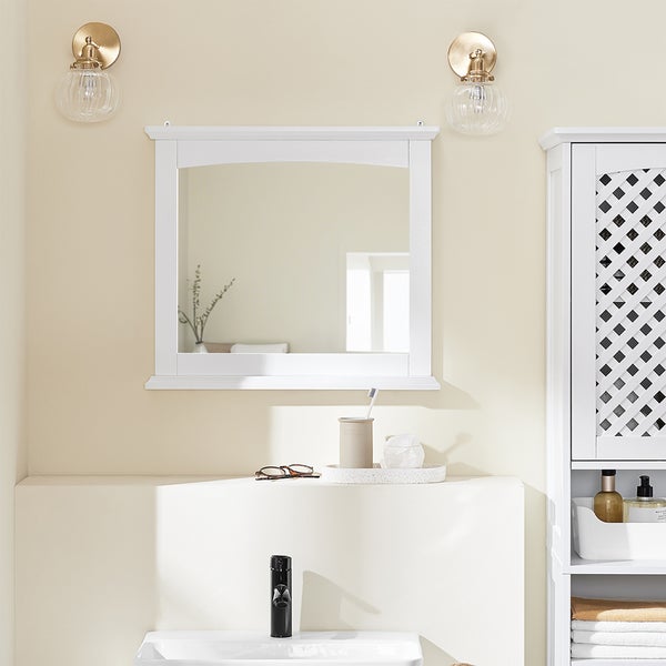 Badezimmer mit Spiegel, Waschbecken, Armatur und Beleuchtung für eine helle und organisierte Atmosphäre.