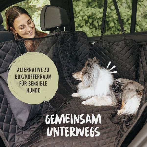 Hund liegt entspannt in einer Autoschondecke mit Steppmuster, während eine Frau lächelt.