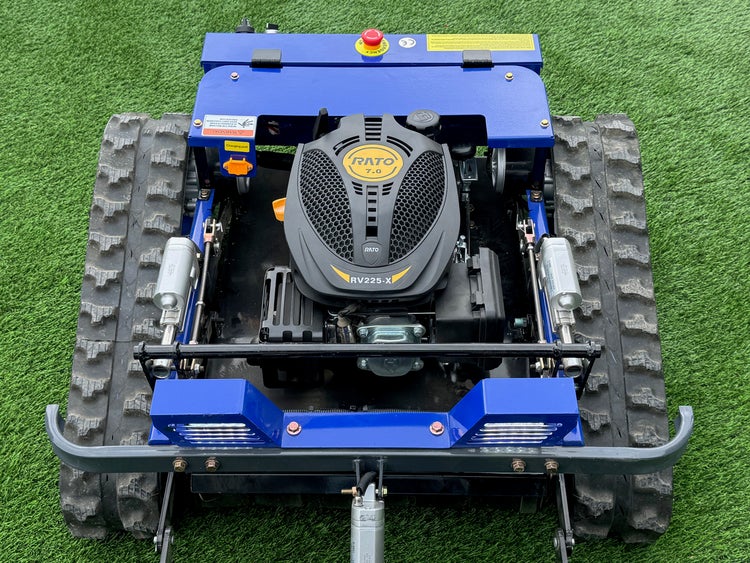 Ferngesteuerter Raupenmäher mit Benzinmotor und blauen Gehäuseteilen, Ansicht von oben auf die Kettenlaufwerke und den Motorblock.