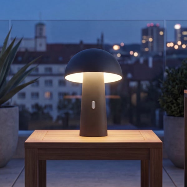 Moderne LED Tischleuchte in Pilzform auf einem Holztisch auf einem Balkon bei Abenddämmerung