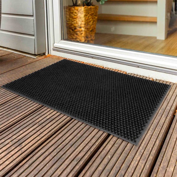 Schmutzfangmatte vor einer Tür auf Holzterrasse