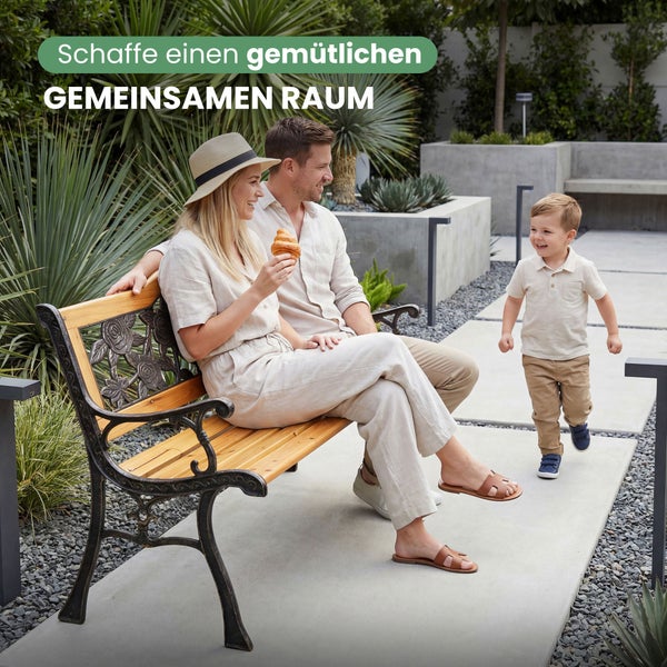 Familie sitzt auf einer Gartenbank aus Holz und Metall in einem modern gestalteten Garten mit Kies und Betonpflanzern.