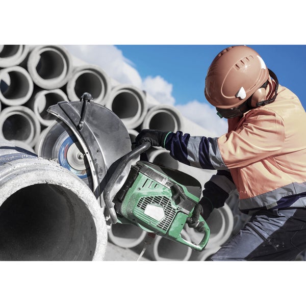 Ein Bauarbeiter schneidet ein Betonrohr mit einer Steintrennmaschine.