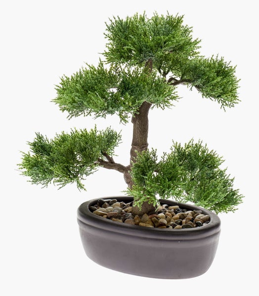 Künstlicher grüner Bonsai-Baum in einem ovalen dunklen Pflanztopf mit kleinen Steinen.