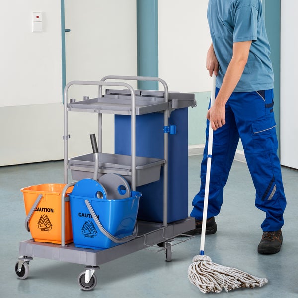 Reinigungswagen mit zwei Eimern, Abfallbehälter und Wischmopp, bedient von einer Person in Arbeitskleidung in einem hellen, sauberen Raum.