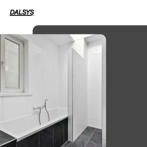 Modernes, helles Badezimmer mit Fenster, Badewanne, weißen Fliesen, Fliesenprofilen an den Kanten und dunklem Boden. DALSYS Logo.