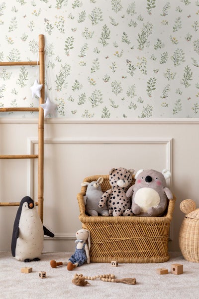 Helles Schlafzimmer mit botanischer Mustertapete, weißem Holzboden, einem Bett mit Strickdecke und einer alten Holztür.