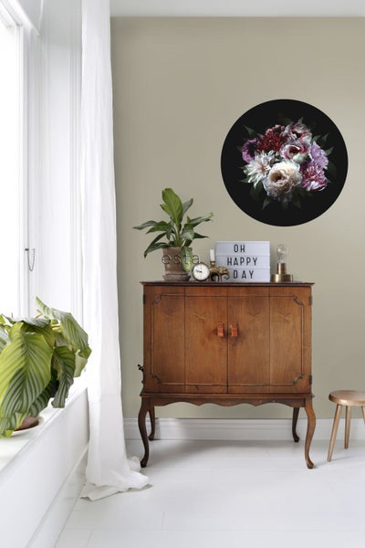 Raumansicht mit Kommode, Zimmerpflanzen und Wanddekoration mit Blumenmotiv