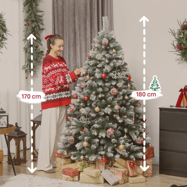 Frau schmückt einen 180 Zentimeter hohen künstlichen Weihnachtsbaum mit Schneeeffekt, roten und goldenen Kugeln sowie Geschenken am Fuß.