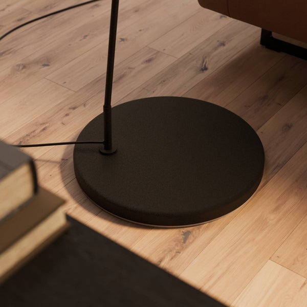 Detailansicht des runden Fußes einer Stehlampe auf einem Holzboden