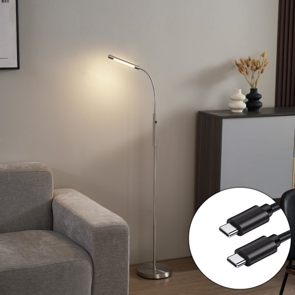 Moderne LED Stehleuchte aus Metall mit flexiblem Hals und USB C Anschluss neben einem grauen Sofa in einem hellen Wohnzimmer.