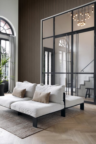 Wohnzimmer mit Couch, Teppich und Glastüren