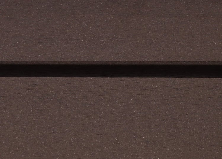 Nahaufnahme einer Terrassendiele aus Holz-Kunststoff-Verbundwerkstoff in Braun mit strukturierter Oberfläche und horizontaler Fuge.