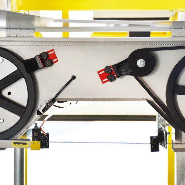 Detailansicht einer Bandsäge mit Sägeblatt, Rädern und Reinigungsbürsten.