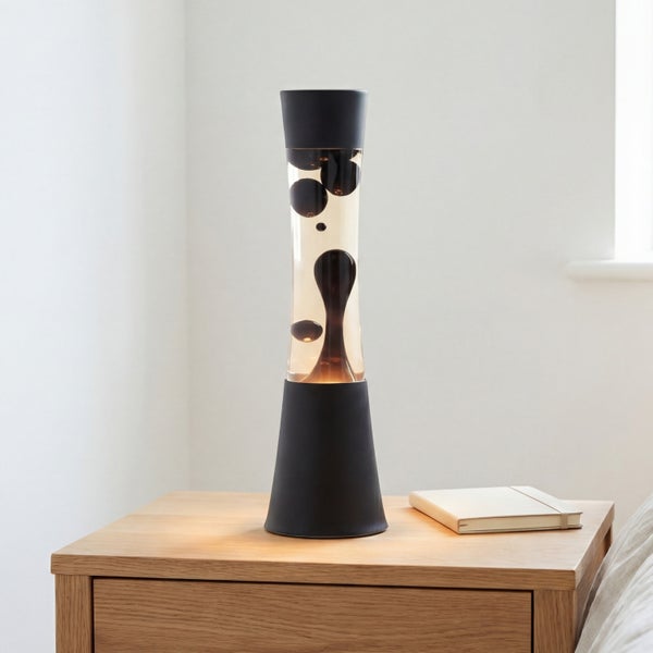 Moderne Lavalampe mit zylindrischem Glasgehäuse und Standfuß auf einem Holznachtisch stehend