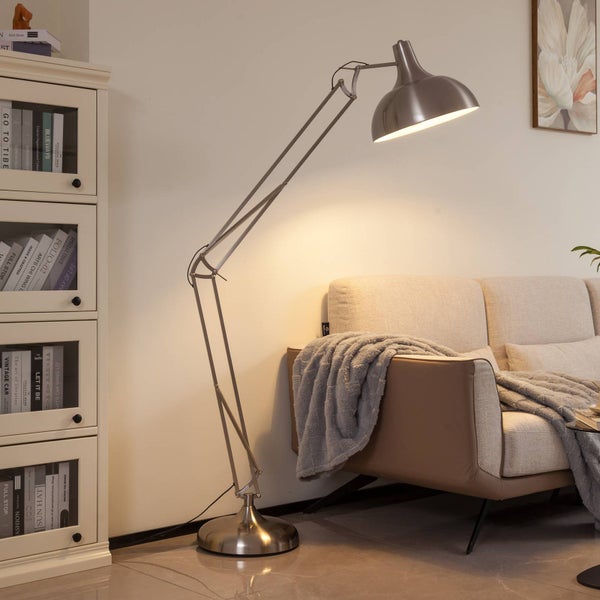 Stehlampe mit verstellbarem Arm neben einem Sofa und einem Bücherregal