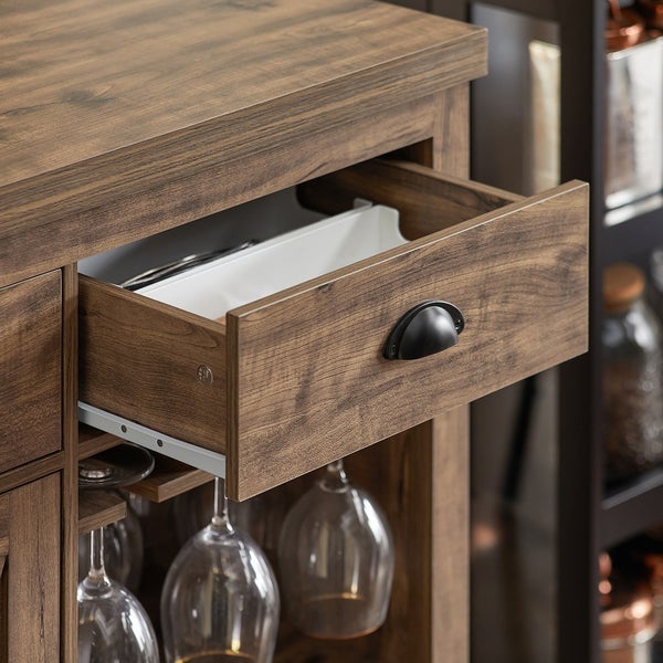 Detailaufnahme eines offenen Schubfachs eines Holzschranks mit Gläserhaltern