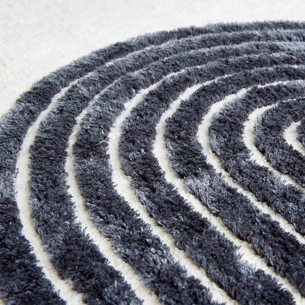 Detailaufnahme eines runden Teppichs mit konzentrischen Streifenmuster