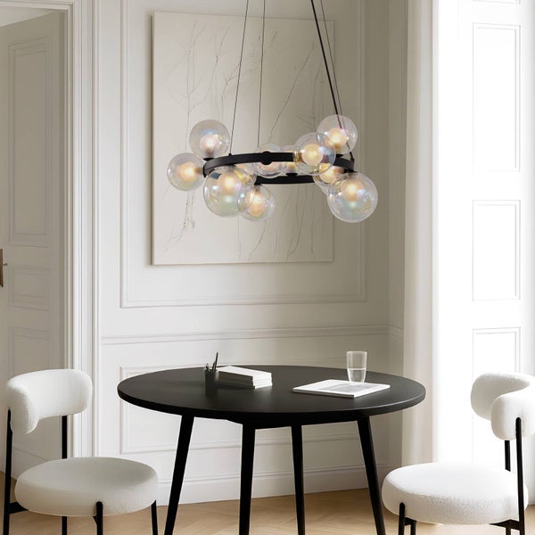 Esszimmer mit rundem Tisch, Stühlen und einer Hängeleuchte mit Glaskugeln