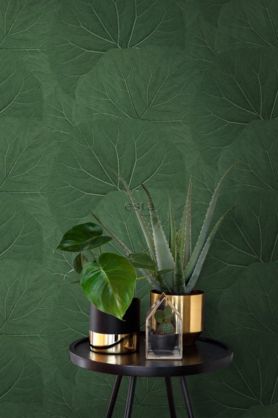 Dekorative Tapete mit Pflanzenmotiven hinter Tisch mit Zimmerpflanzen