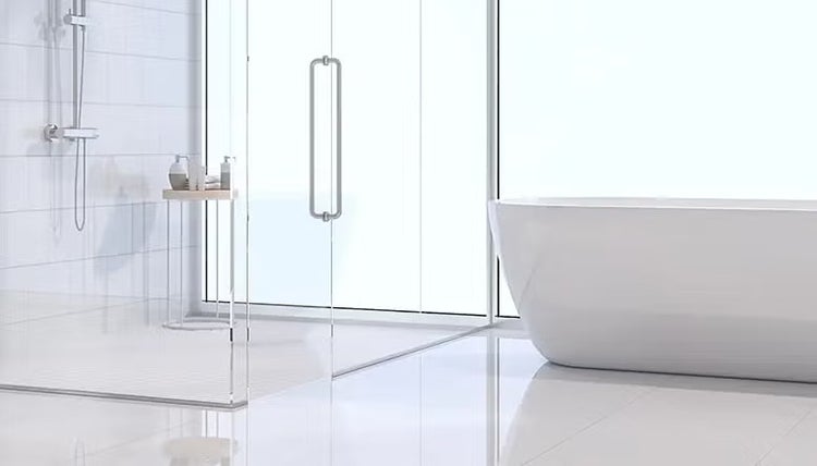 Modernes, helles Badezimmer mit Glasdusche, Duschset und einer freistehenden weißen Badewanne auf hellem Fliesenboden.