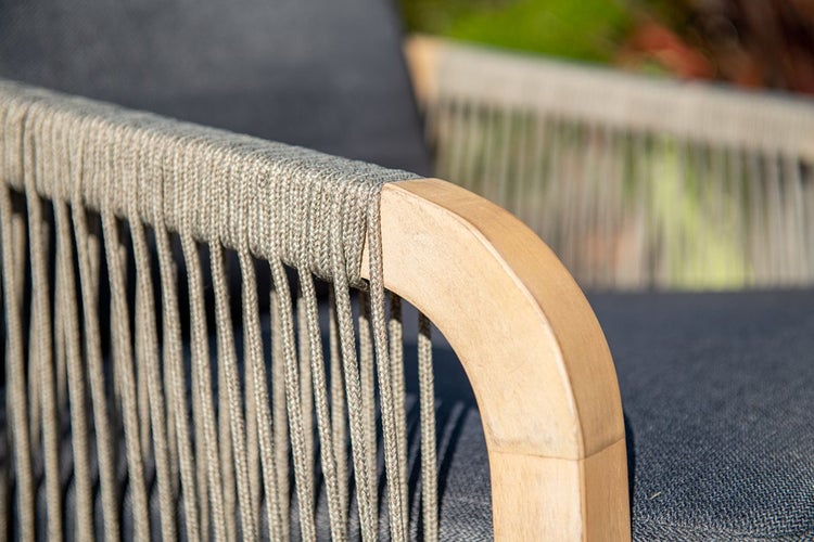 Nahaufnahme einer hölzernen Armlehne mit vertikaler Seilbespannung an einem Gartenstuhl.