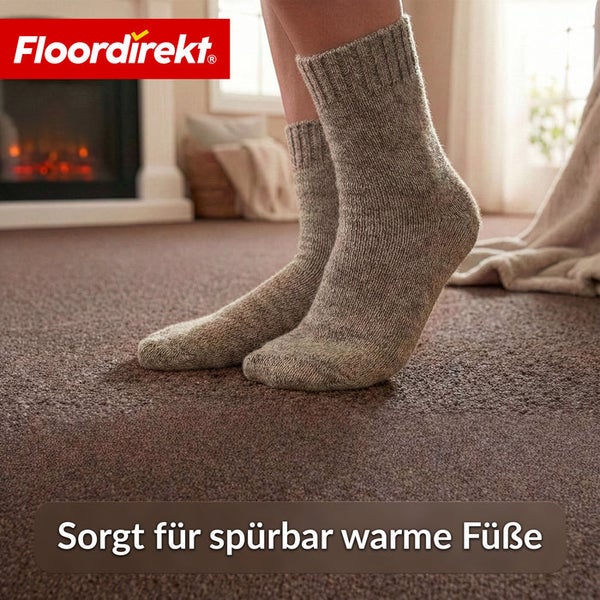 Person mit Wollsocken auf Teppichboden. Floor direkt Logo.