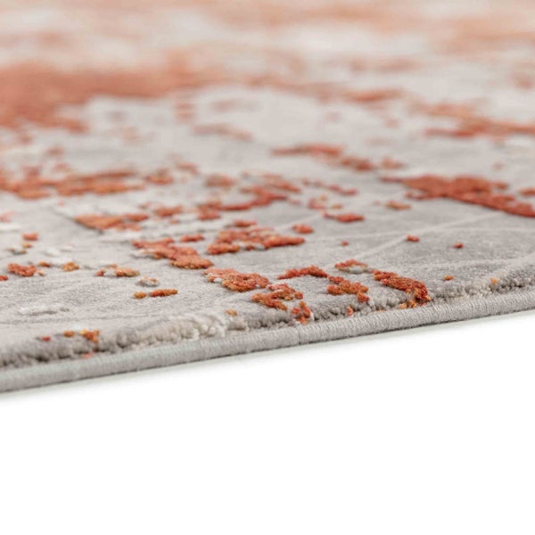 Nahaufnahme eines Teppichs mit abstraktem Muster und geketteltem Rand.