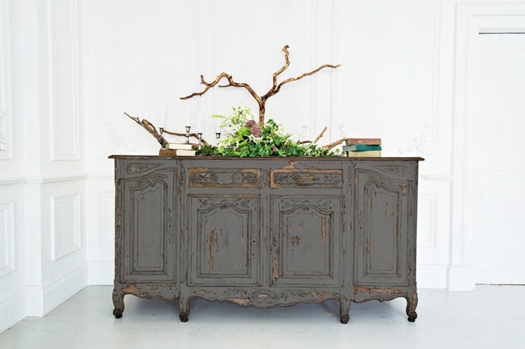 Antikes Sideboard im Landhausstil mit floraler Dekoration und Büchern