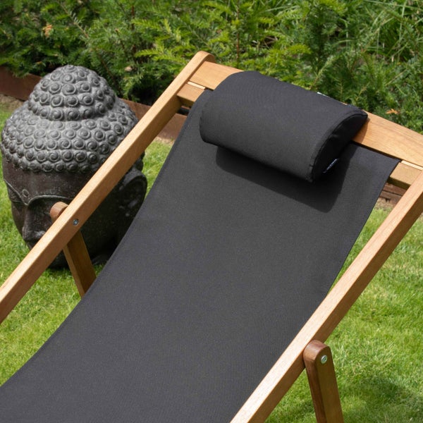 Klappbarer Holz-Liegestuhl mit schwarzem Stoffbezug und Nackenkissen im Garten neben einer Buddha-Statue.